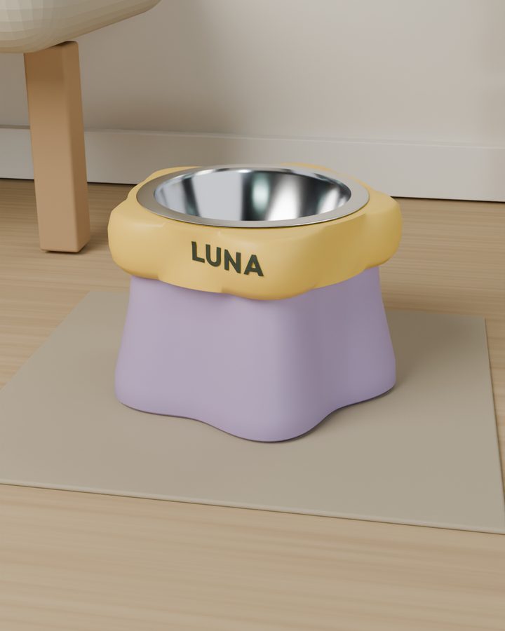 Soporte LEAL en forma de flor, lila y amarillo, con el nombre LUNA, en una sala
